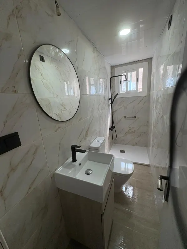 Vista general de baño reformado en mármol - Barcelona